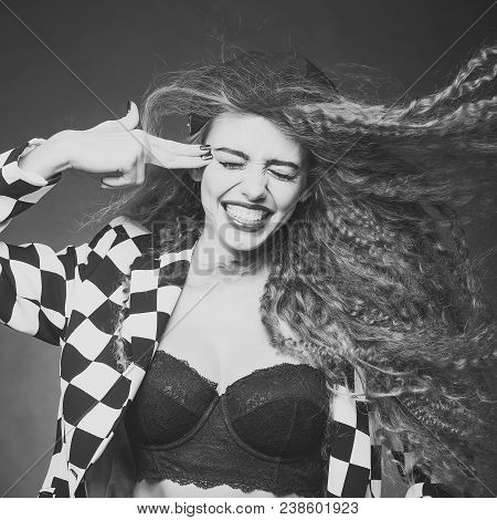 Attractive Woman With Fly-away Wavy Long Hair Wearing Black And White Cardigan Cap Underwire Bra Jea
