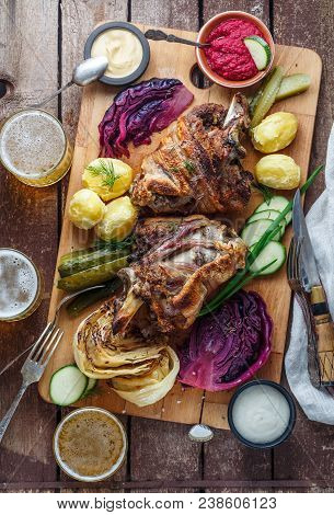 Roasted Pork Knuckle Eisbein With Braised Boiled Cabbage, Potato, Pickles, Dip And Beer, Top View.