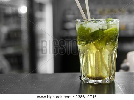 Closeup Glass Of Unalcohol Mohito Cocktail With Lime And Mint And With A Two Tubes At Bar Background