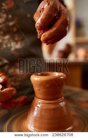 Close-up Hands Of A Male Potter In Plaid Shirt And Dirty Apron Who Molds A Vase From Clay, Selective