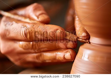 Close-up Hands Of A Male Potter In Plaid Shirt And Dirty Apron Who Molds Bowl From Clay, Selective F