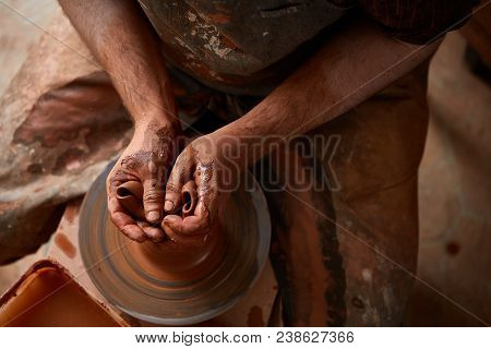 Close-up Hands Of A Male Potter In Plaid Shirt And Dirty Apron Who Molds Bowl From Clay, Selective F