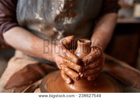 Close-up Hands Of A Male Potter In Plaid Shirt And Dirty Apron Who Molds Bowl From Clay, Selective F