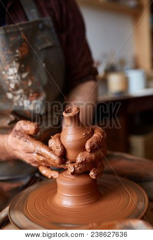 Close-up Hands Of A Male Potter In Plaid Shirt And Dirty Apron Who Molds Bowl From Clay, Selective F
