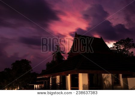 A Beach Bungalow At Night In Front Of A Dramatic Sky With An Incoming Thunder Storm During Rainy Sea