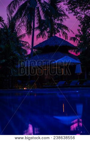 A Pool Side Traditional Thai Style Bungalow At A Luxury Resort In Krabi, Thailand  With A Purple Lit