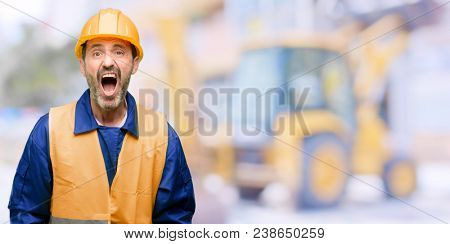 Senior engineer man, construction worker stressful, terrified in panic, shouting exasperated and frustrated. Unpleasant gesture. Annoying work drives me crazy at work