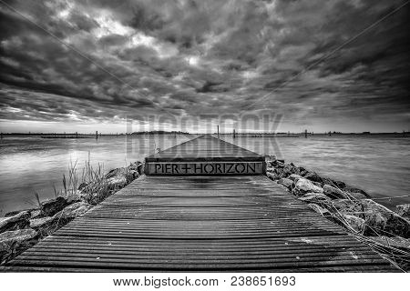Landart In The Netherlands. Vista With Water, Jetty And Nature Under A Beautiful Cloudy Sky With Sun
