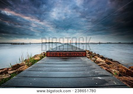 Landart In The Netherlands. Vista With Water, Jetty And Nature Under A Beautiful Cloudy Sky With Sun