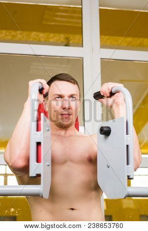 Mixed Race Fitness Man Is Working Out On Butterfly Machine In Gym.