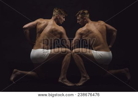 Fitness Dieting And Flexibility In Acrobatics. Twins Men With Muscular Body In Pose. Circus Gymnasts