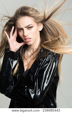 Lady Sexy In Slicker Or Raincoat Suffers Headache. Girl With Long Hair Wears Black Cloak, Grey Backg