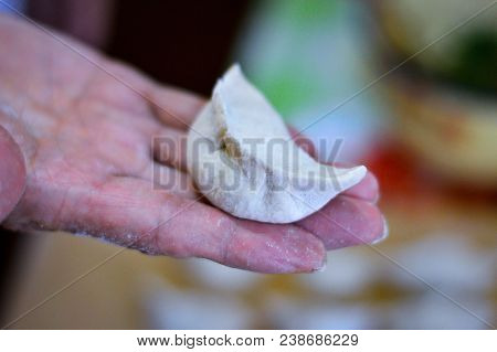 Close-up Of Chinese Uncooked Dumpling Placed On A Hand. The Dumpling, Called Jiaozi In Chinese, Is A