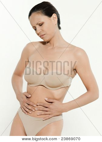 ภาพเหมือนของผู้หญิงเอเชียใน undergarments มีการปวดระดูในสตูดิโอบนพื้นแยก