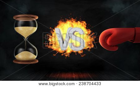 3d Rendering Of A Concrete Letters Vs Caught On Fire Between An Hourglass And A Red Boxing Glove. Ti