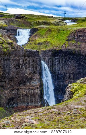 Complex of high waterfalls of Haifoss in a dangerous tundra canyon. Cloudy and windy summer day in Iceland. The concept of extreme and phototourism
