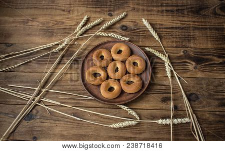 Bagels In A Plate With Spikelets On Wooden Background