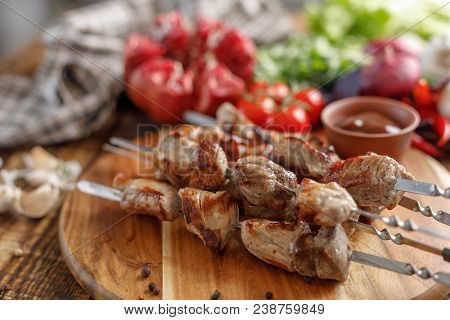 Shish Kebab From Pork And Fresh Vegetables On A Wooden Background. Appetizing Meat Cooked On An Open