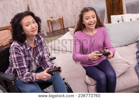 Video Games. Glad Incapacitated Woman Looking At Camera While Using Controller With Girl