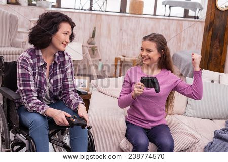 My Victory. Joyful Incapacitated Woman And Girl Holding Controller While Smiling