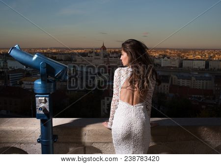 Young Girl In White Dress Look With Binoculars On City Skyview. Woman With Touristic Telescope.