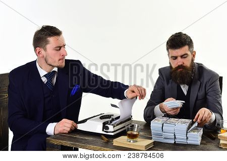 Illegal Business Concept. Men Sitting At Table With Piles Of Money And Typewriter. Company Engaged I