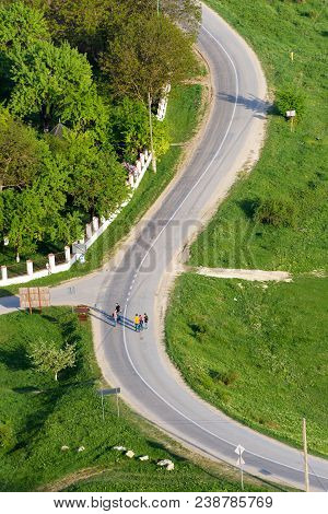 People Crossing A Winding S Curved Road In Trebujeni Village