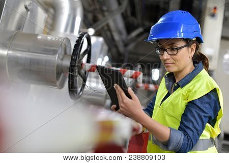 Industrial technician connected with tablet in recyling plant