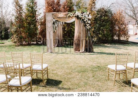 Arch For The Wedding Ceremony, Decorated With Cloth And Flowers. Ceremony Zone View