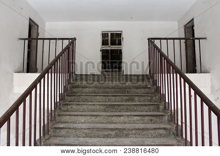 Concrete Stairway With Metal Handrails Leading To Attic Of Dilapidated Abandoned Building With Missi