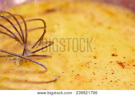 Egg Mixture In Glass Bowl With Wisk And Seasoning.
