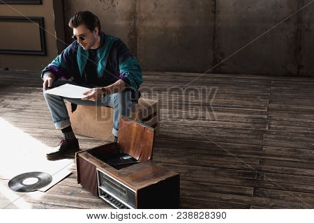 Thoughtful Nostalgic Man In Vintage Windcheater With Vinyl Record Player