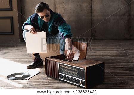Handsome Nostalgic Man In Vintage Windcheater With Vinyl Record Player