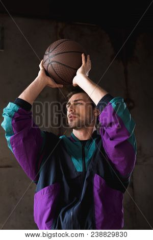 Stylish Young Man In Vintage Windcheater Throwing Basketball Ball