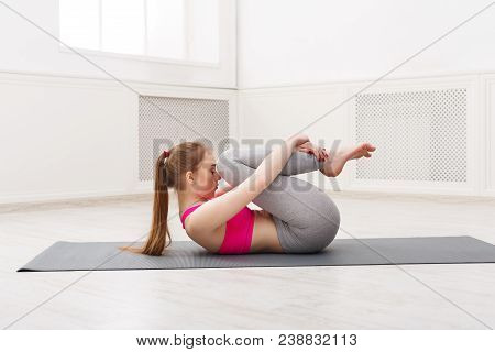 Fitness, Woman Yoga Relax Meditation In Wind-relieving Pose At Home. Young Slim Girl Makes Exercise.