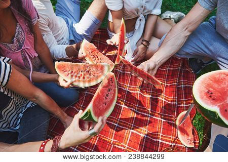 Cheerful Friends Enjoying Watermelon On Picnic On Sunny Summer Day.
