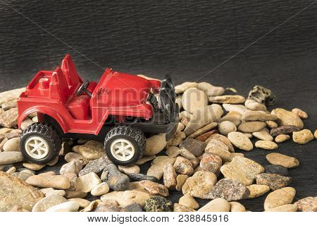Close-up Of Nice Scale Model Of Sport Utility Vehicle Parking On Pebbles. Vintage Automobile In Mini