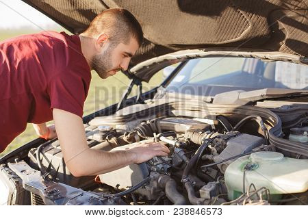 Photo Of Male Stands In Front Of Opened Car Hood, Has Brocken Vehicle On Road, Tries To Solve Proble