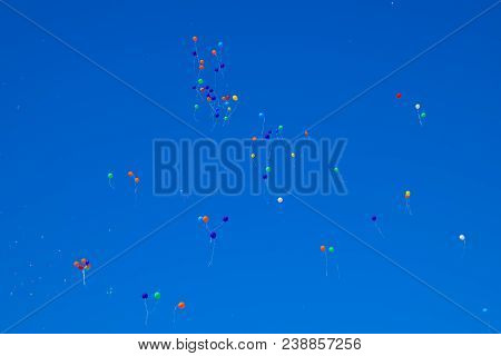 Multicolored Balls, Filled With Helium, Fly In The Blue Sky.