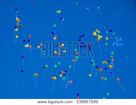 Multicolored Balls, Filled With Helium, Fly In The Blue Sky.