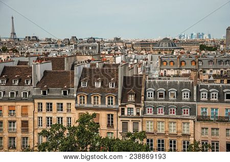 Facade Close-up Of Typical Semidetached Buildings And Eiffel Tower On The Horizon In Paris. Known As