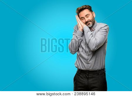 Middle age man, with beard and bow tie tired and bored, tired because of a long day overworking