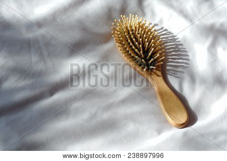 Hair Fall, Hair Loss Problem. Wooden Brown Comb With Hair Loss On White Bed Cover. Woman Healthy And