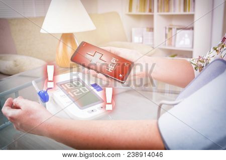 Woman measuring blood pressure at home and using simple user-friendly smart phone application to call rescue team to prevent heart attack