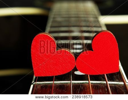 Red Hearts On The Strings Of A Guitar. Hearts Are A Symbol Of Love. Strings Of The Heart.