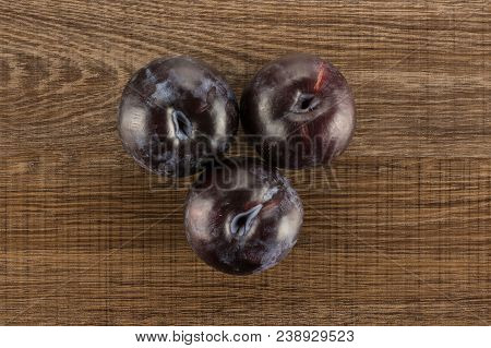 Three Red Blue Plums Table Top Isolated On Brown Wood Background Round Whole Fresh Juicy Fruit