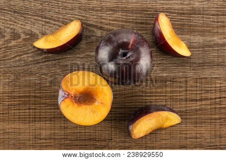 Red Blue Plums Set Table Top Isolated On Brown Wood Background One Whole One Section Half Three Slic