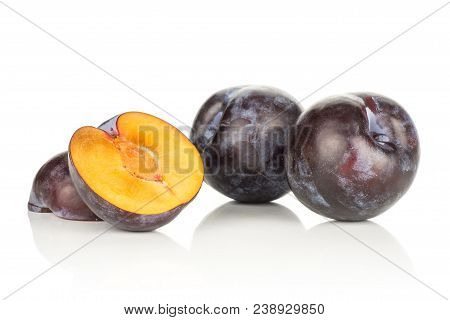 Two Red Blue Plums And Two Sliced Halves Isolated On White Background