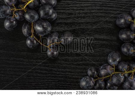 Black Grape Two Clusters (autumn Royal Variety) Table Top Isolated On Black Wood Background
