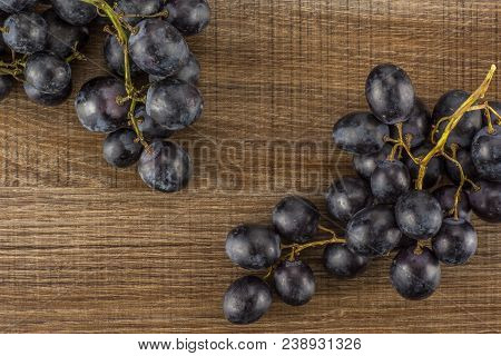 Black Grape Two Clusters (autumn Royal Variety) Table Top Isolated On Brown Wood Background